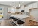 Beautiful kitchen with white cabinets, a quartz island, and stainless steel appliances with bar stool seating at 6423 Mallow Crossing Ln, Charlotte, NC 28213