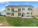 Spacious backyard featuring a well-maintained lawn, large windows, and a patio with outdoor seating at 6430 Stirling Ln, Indian Land, SC 29707
