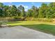 Large backyard with a patio, wooden fence, and mature trees, creating a serene outdoor space at 6430 Stirling Ln, Indian Land, SC 29707