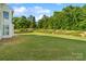 Vast backyard with lush green grass and a wooded area, providing privacy and a natural setting at 6430 Stirling Ln, Indian Land, SC 29707