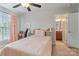 Bright bedroom with neutral walls, pink drapes and a view of an en-suite bath at 6430 Stirling Ln, Indian Land, SC 29707