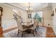Elegant dining area with a chandelier, large window, and views of the stairway at 6430 Stirling Ln, Indian Land, SC 29707