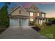 Elegant brick home with a two-car garage, well-manicured landscaping, and covered front porch at 6430 Stirling Ln, Indian Land, SC 29707