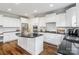 Modern white kitchen featuring an island with a black countertop and stainless steel appliances at 6430 Stirling Ln, Indian Land, SC 29707