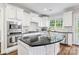 Bright kitchen with white cabinets, black countertops, a central island, and stainless steel appliances at 6430 Stirling Ln, Indian Land, SC 29707