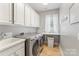 Well-lit laundry room featuring modern washer and dryer and overhead storage cabinets at 6430 Stirling Ln, Indian Land, SC 29707