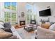 Bright living room featuring tall windows, a fireplace, and hardwood floors at 6430 Stirling Ln, Indian Land, SC 29707
