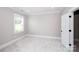 Neutral bedroom featuring carpeting, a window, and a door to a walk-in closet at 720 Cavesson Way, Monroe, NC 28110