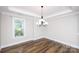 Bright dining room featuring hardwood floors, a modern chandelier, and large windows, ideal for entertaining at 720 Cavesson Way, Monroe, NC 28110