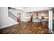 Open-concept living space with hardwood floors, modern kitchen, staircase and abundant natural light at 720 Cavesson Way, Monroe, NC 28110