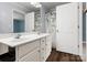 Bathroom with a double vanity, wooden floors, leafy patterned shower curtain, and a large mirror at 730 Cove Rd, Gastonia, NC 28052