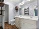 Bathroom featuring a double vanity with white cabinets, wood floors, and decorative shelves at 730 Cove Rd, Gastonia, NC 28052