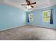 Large bedroom with carpet flooring, a ceiling fan, and two bright windows with natural lighting at 730 Cove Rd, Gastonia, NC 28052