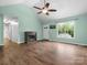A large living room with laminate floors, a ceiling fan, a fireplace, and lots of natural light at 730 Cove Rd, Gastonia, NC 28052