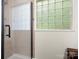 Tiled shower enclosure with a black handle, glass door, and a window letting in natural light at 730 Cove Rd, Gastonia, NC 28052