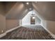 Large unfinished attic space featuring a ceiling fan, neutral paint, and gray carpeting at 7703 Juniper Ln, Denver, NC 28037
