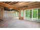 Unfinished basement with exposed beams, concrete floor, and sliding glass door leading to the backyard at 7703 Juniper Ln, Denver, NC 28037