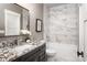 Bathroom featuring granite counters, rectangular mirror, tub/shower combination with stylish tile surround at 7703 Juniper Ln, Denver, NC 28037