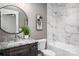 Modern bathroom featuring granite counters, round mirror, tub/shower combination with stylish tile surround at 7703 Juniper Ln, Denver, NC 28037