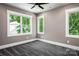 Bedroom with neutral colors, gray carpet, white trim, ceiling fan and two bright windows at 7703 Juniper Ln, Denver, NC 28037