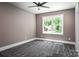 Empty bedroom featuring large windows, natural light, and neutral gray carpet and walls at 7703 Juniper Ln, Denver, NC 28037
