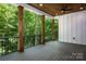 Covered deck with a ceiling fan overlooking a lush wooded area at 7703 Juniper Ln, Denver, NC 28037
