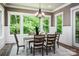 Bright dining room with views of a beautiful wooded landscape and an elegant chandelier at 7703 Juniper Ln, Denver, NC 28037