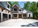Front exterior showcasing stone accents, modern garage doors, and elegant wooden entry at 7703 Juniper Ln, Denver, NC 28037