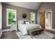 Comfortable main bedroom with a sliding wood door and views of nature from large windows at 7703 Juniper Ln, Denver, NC 28037
