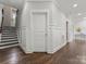 Hallway with wainscotting, wood floors, a staircase, and multiple doors at 859 Academy St, Charlotte, NC 28205