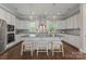 Open kitchen with sleek white cabinets, stainless steel appliances, and an island with barstool seating at 859 Academy St, Charlotte, NC 28205