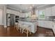 Bright kitchen with a large granite island with seating, stainless appliances, and recessed lighting at 859 Academy St, Charlotte, NC 28205