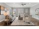 Inviting living room with a plush sofa, patterned armchairs, a ceiling fan, and large windows for natural light at 859 Academy St, Charlotte, NC 28205