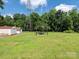Spacious backyard features storage sheds and an outdoor seating area under high-tension wires at 876 Stowe Ln, Gastonia, NC 28056