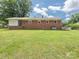 Backyard view with mature lawn and the brick home at 876 Stowe Ln, Gastonia, NC 28056