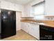 Functional kitchen with white cabinets, black appliances, and a stainless steel sink at 876 Stowe Ln, Gastonia, NC 28056