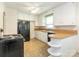 Functional kitchen featuring white cabinetry, black appliances, and a breakfast bar, blending style and practicality at 876 Stowe Ln, Gastonia, NC 28056