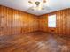 Cozy room featuring wood paneling, hardwood floors, and a ceiling fan at 876 Stowe Ln, Gastonia, NC 28056
