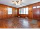 Inviting living room featuring wood-paneled walls, ceiling fan, natural light, and hardwood floors, creating a cozy atmosphere at 876 Stowe Ln, Gastonia, NC 28056