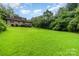 Expansive backyard featuring a brick house with lush greenery at 9139 Robert Frost Ln, Charlotte, NC 28213