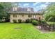 Large backyard featuring a brick house, lush greenery, and an outdoor patio area at 9139 Robert Frost Ln, Charlotte, NC 28213