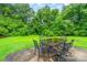 Outdoor patio area with a table and chairs surrounded by lush greenery at 9139 Robert Frost Ln, Charlotte, NC 28213