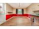 Bright dining room with hardwood floors, red and beige walls, a window, a modern chandelier, and built-in shelving at 9139 Robert Frost Ln, Charlotte, NC 28213