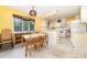 Bright eat-in kitchen features yellow walls, a dining table, white cabinets, and tiled floors perfect for cooking and casual dining at 9139 Robert Frost Ln, Charlotte, NC 28213