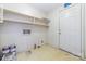 Bright laundry room featuring built-in shelving and a white door at 9139 Robert Frost Ln, Charlotte, NC 28213