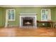 The living room features a brick fireplace with white mantle, two windows and hardwood floors. Perfect for relaxing at 9139 Robert Frost Ln, Charlotte, NC 28213