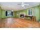 Inviting living room features green walls, hardwood floors, a ceiling fan and a brick fireplace for cozy gatherings at 9139 Robert Frost Ln, Charlotte, NC 28213