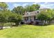 Classic home featuring landscaped front yard and brick chimney surrounded by mature trees offering shade and curb appeal at 952 8Th Ne St, Hickory, NC 28601