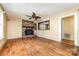 Cozy living room with brick fireplace, hardwood floors, and a ceiling fan with warm lighting at 952 8Th Ne St, Hickory, NC 28601