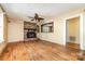 Cozy living room with brick fireplace, hardwood floors, and a ceiling fan with warm lighting at 952 8Th Ne St, Hickory, NC 28601